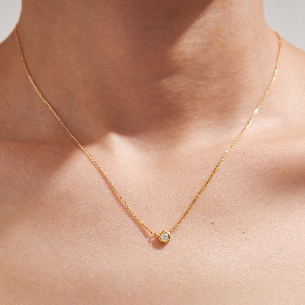 Diamond solitaire pendent necklace, 9k yellowgold on neck